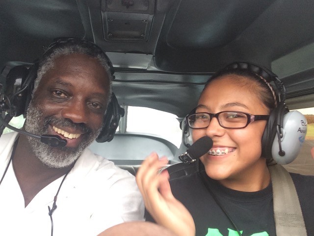 A man and young woman ride in small airplane