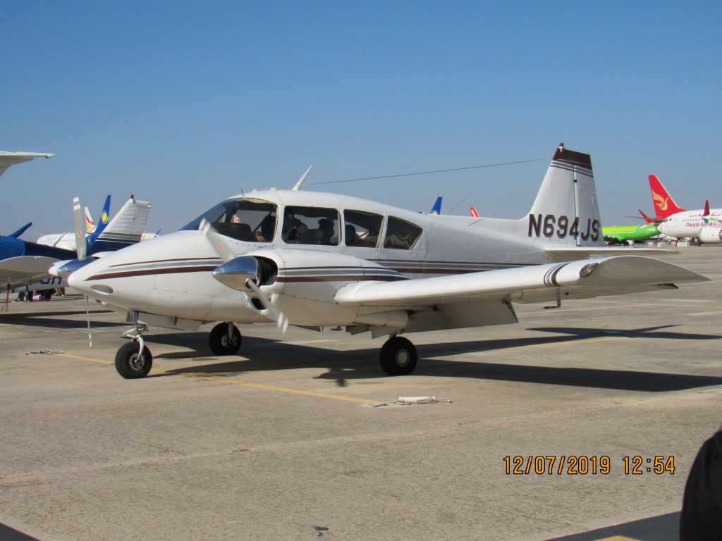 White twin airplane parked out on the ramp
